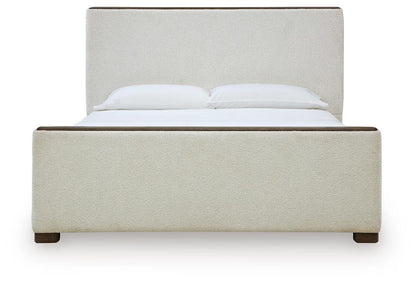 Radkin - Queen Upholstered Panel Bed - Burnished Brown